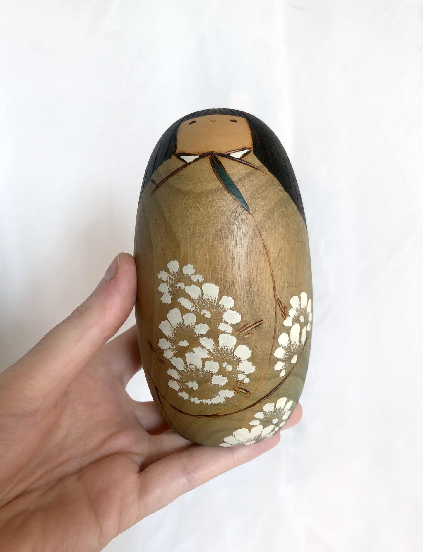 Cute wooden kokeshi doll with delicate flowers pattern by Usaburo
