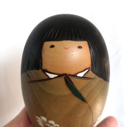 Cute wooden kokeshi doll with delicate flowers pattern by Usaburo