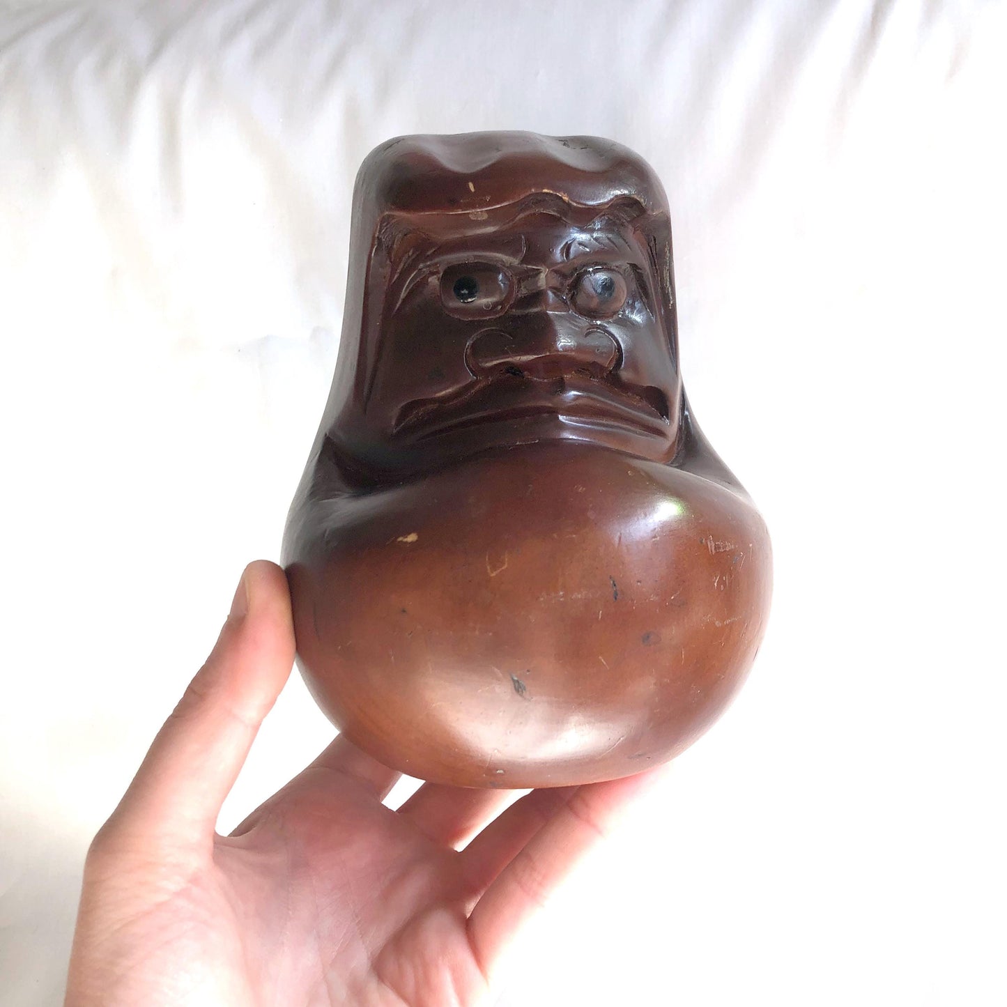Pensive wooden Daruma figurine