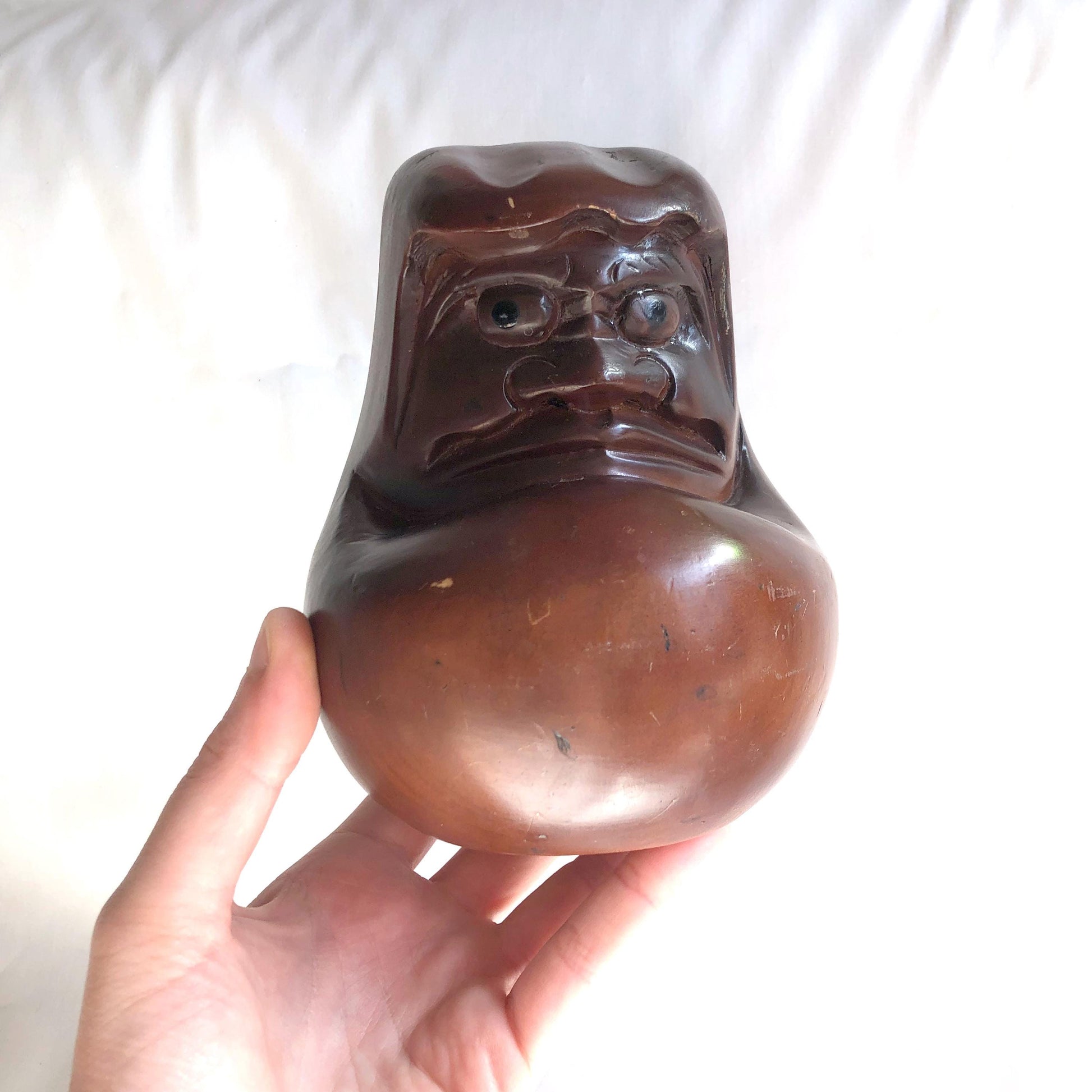 Pensive wooden Daruma figurine