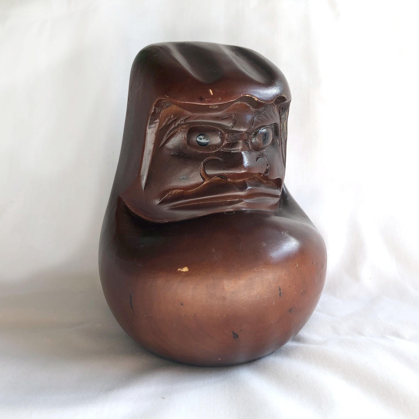 Pensive wooden Daruma figurine
