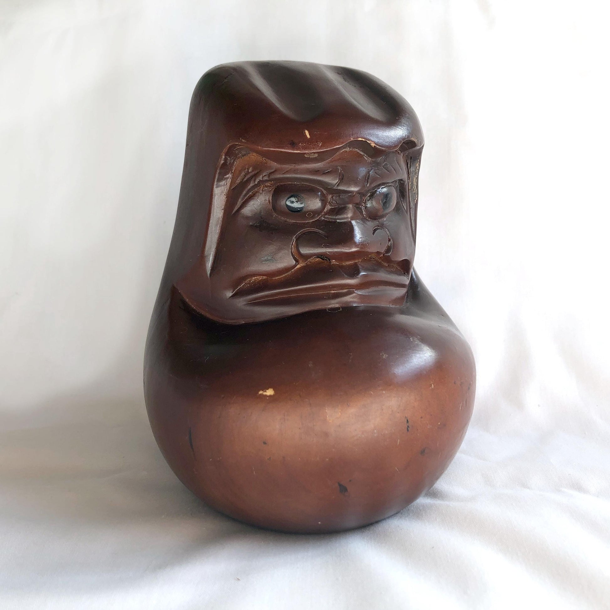Pensive wooden Daruma figurine