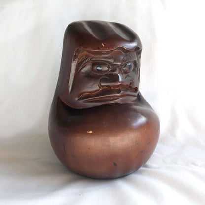 Pensive wooden Daruma figurine