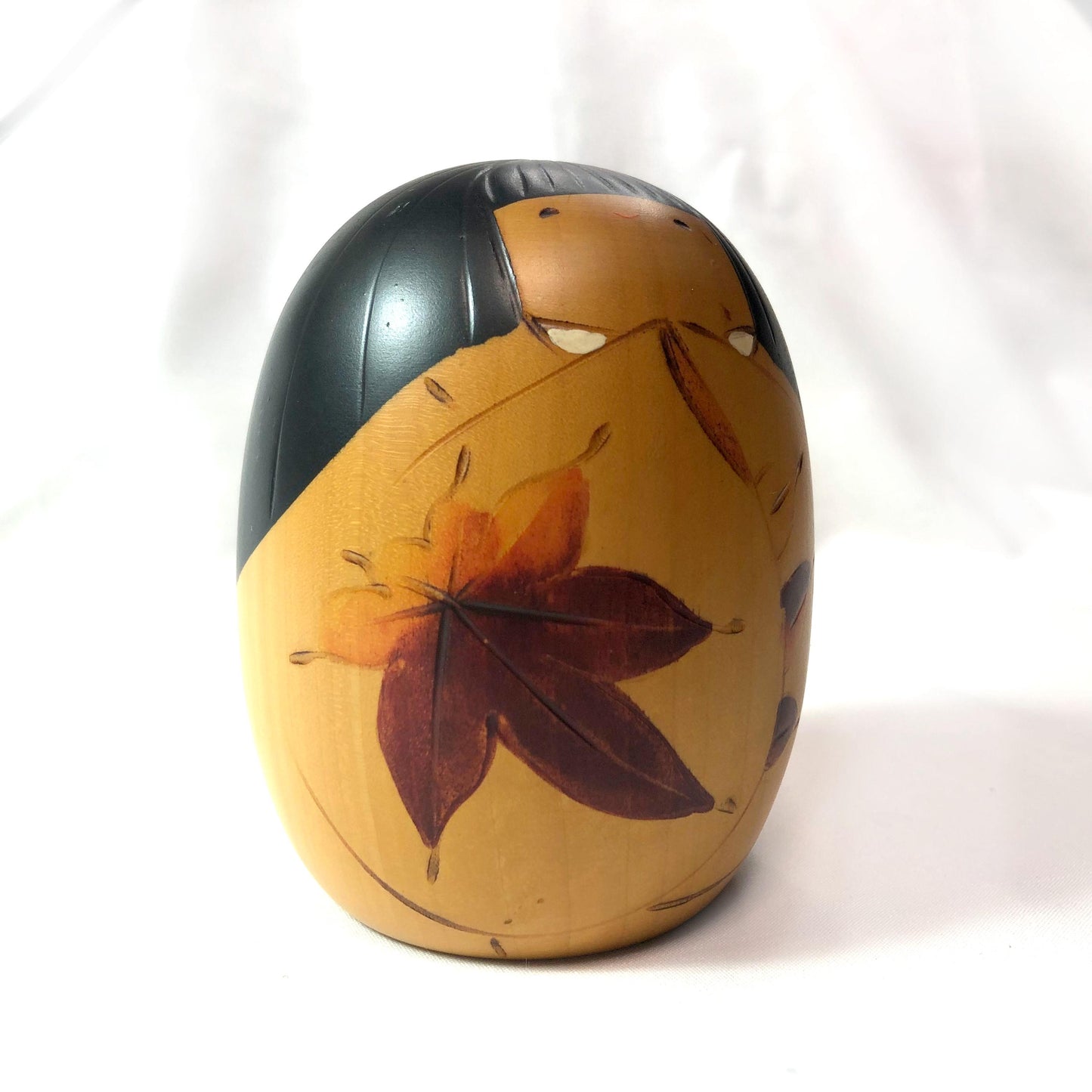 Cute wooden kokeshi doll with momiji leaf pattern by Usaburo