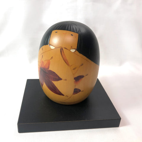 Cute wooden kokeshi doll with momiji leaf pattern by Usaburo