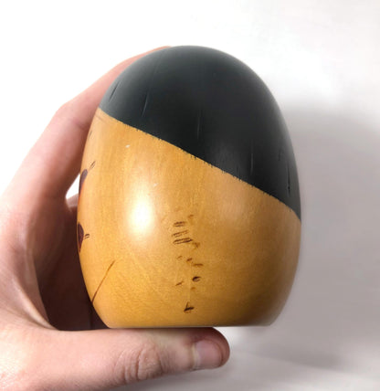 Cute wooden kokeshi doll with momiji leaf pattern by Usaburo