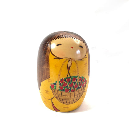 Joyful wooden kokeshi doll with a basket of flowers