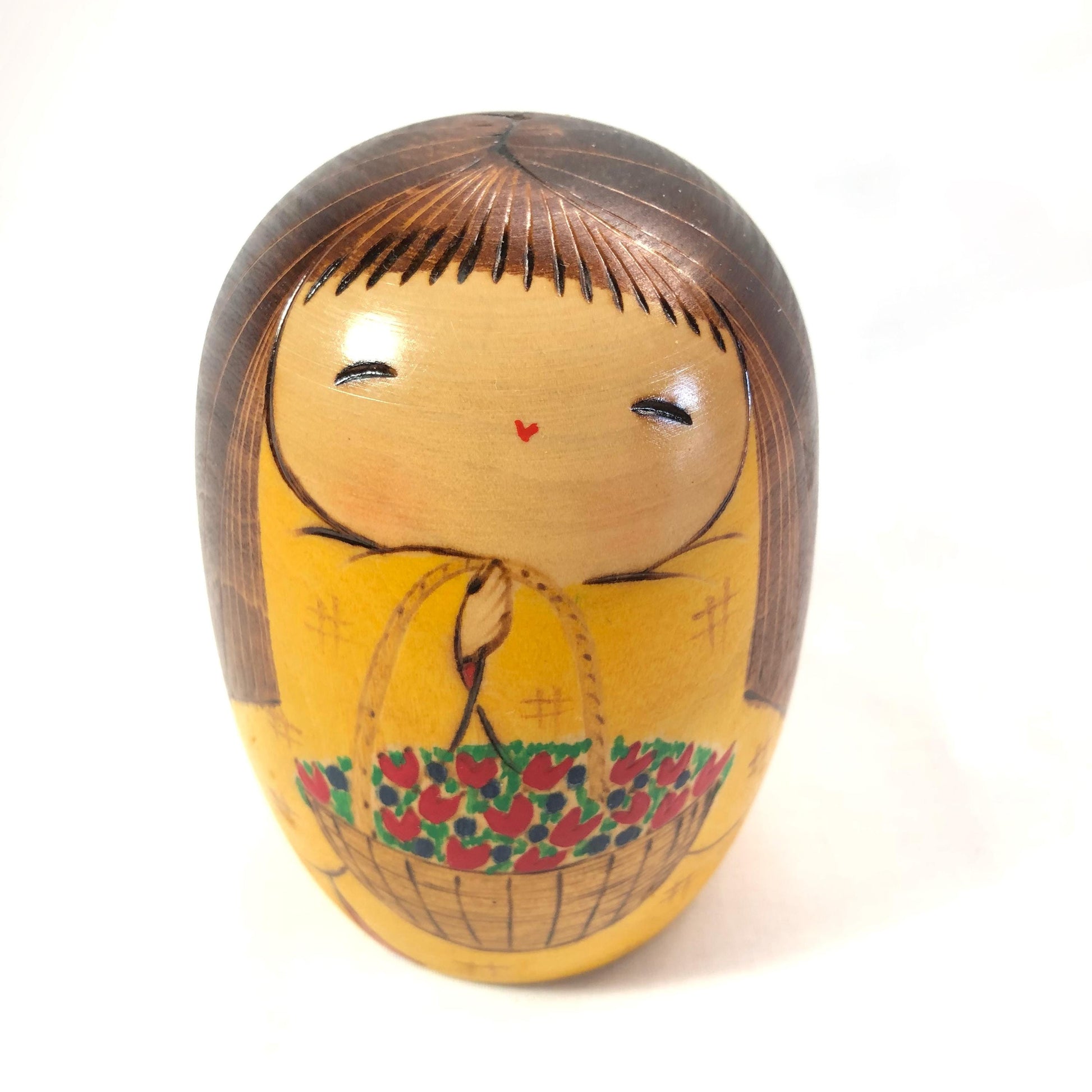 Joyful wooden kokeshi doll with a basket of flowers