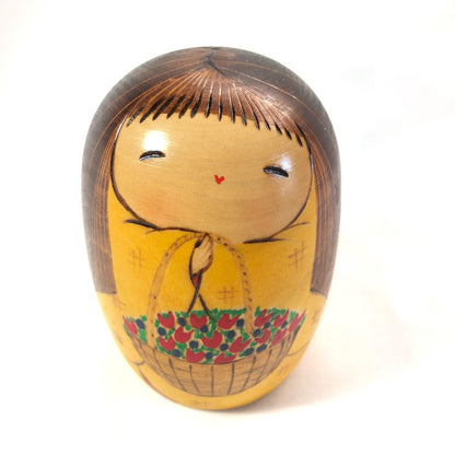 Joyful wooden kokeshi doll with a basket of flowers