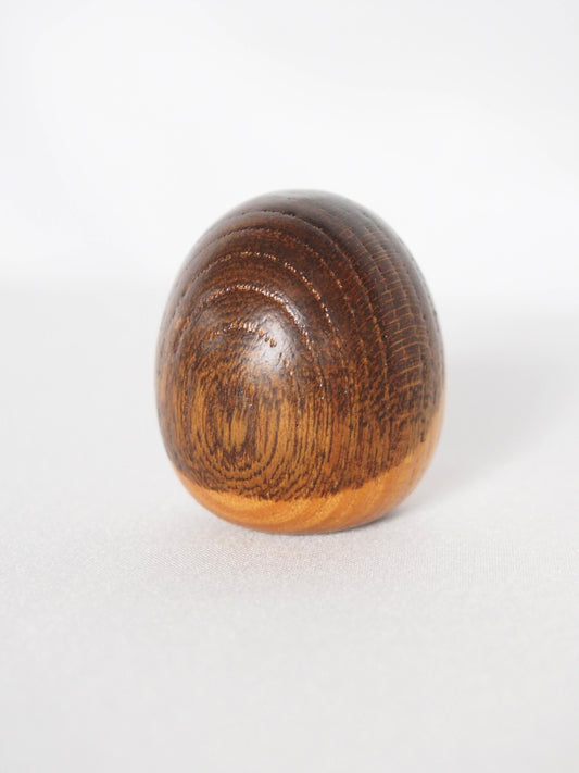 Miniature wooden kokeshi doll with a camellia flower