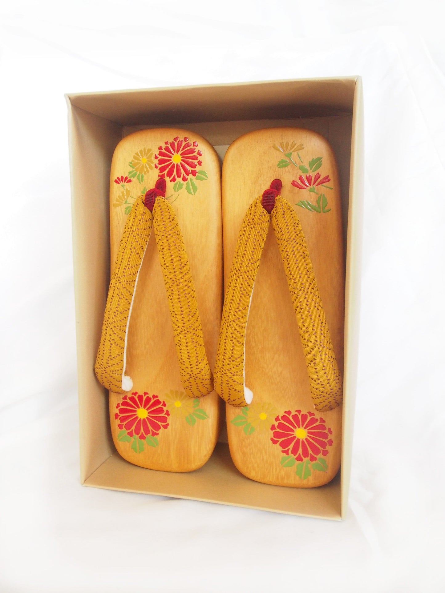 Elegant wooden geta- ocher and red traditional Japanese shoes with floral pattern