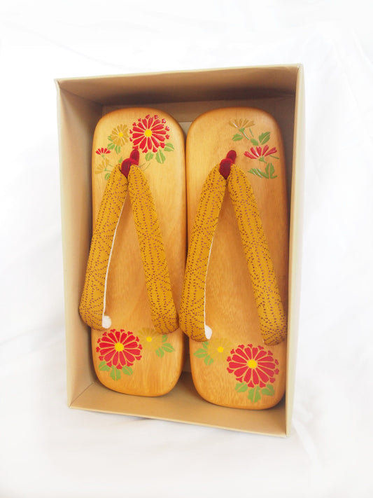Elegant wooden geta- ocher and red traditional Japanese shoes with floral pattern