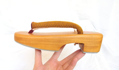 Elegant wooden geta- ocher and red traditional Japanese shoes with floral pattern