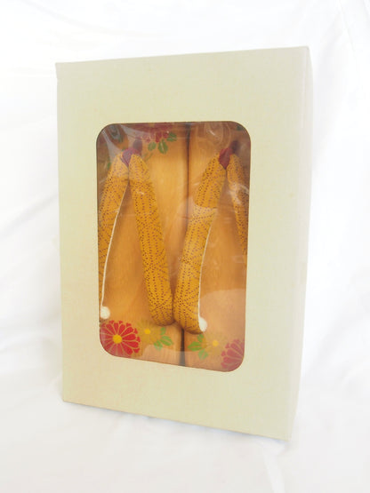 Elegant wooden geta- ocher and red traditional Japanese shoes with floral pattern